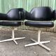 Pair of vintage armchairs in black skai with metal legs.