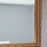 Mirror in gilded stucco wood and beveled glass