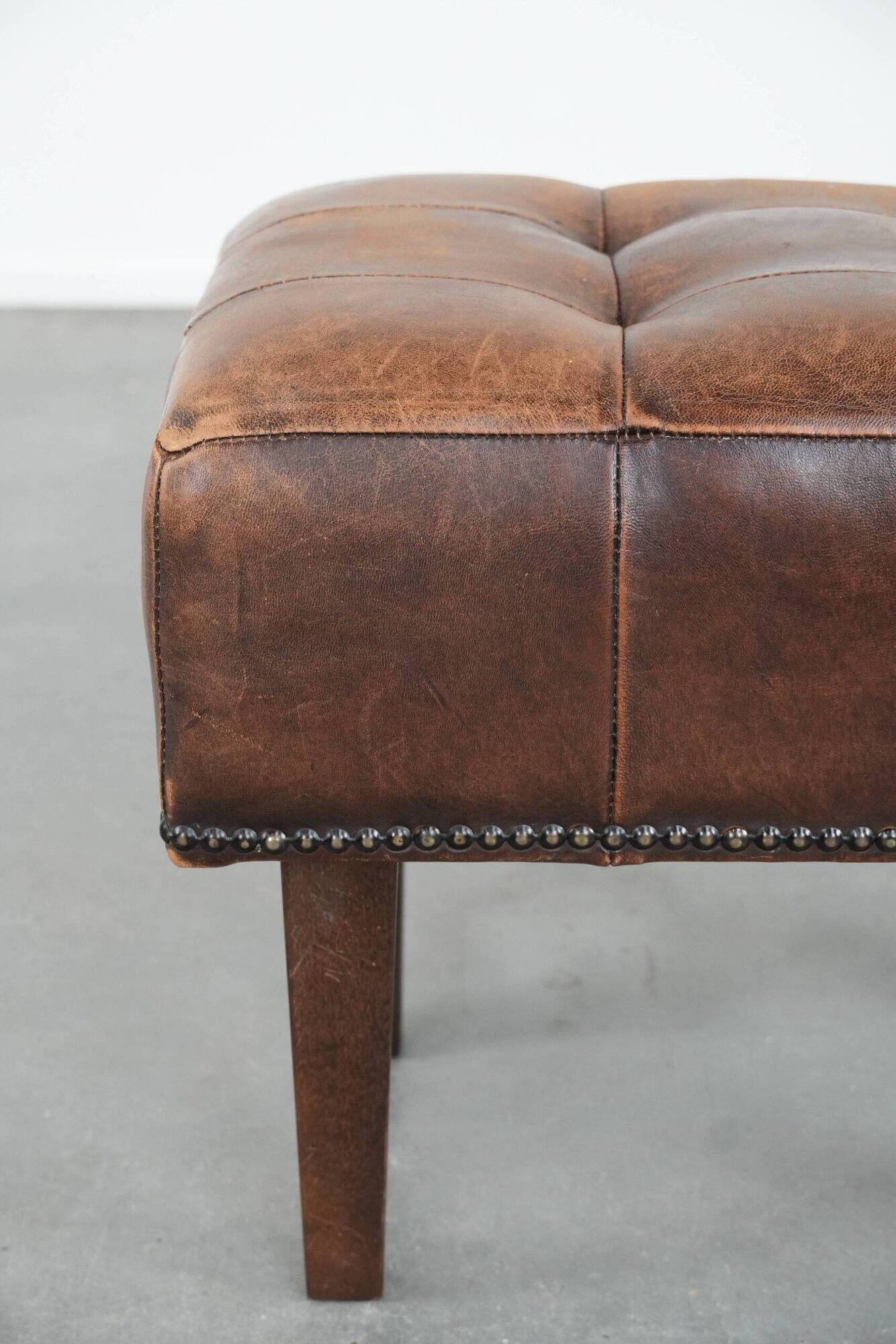 Beautiful sheepskin ottoman on high legs and beautiful warm colours