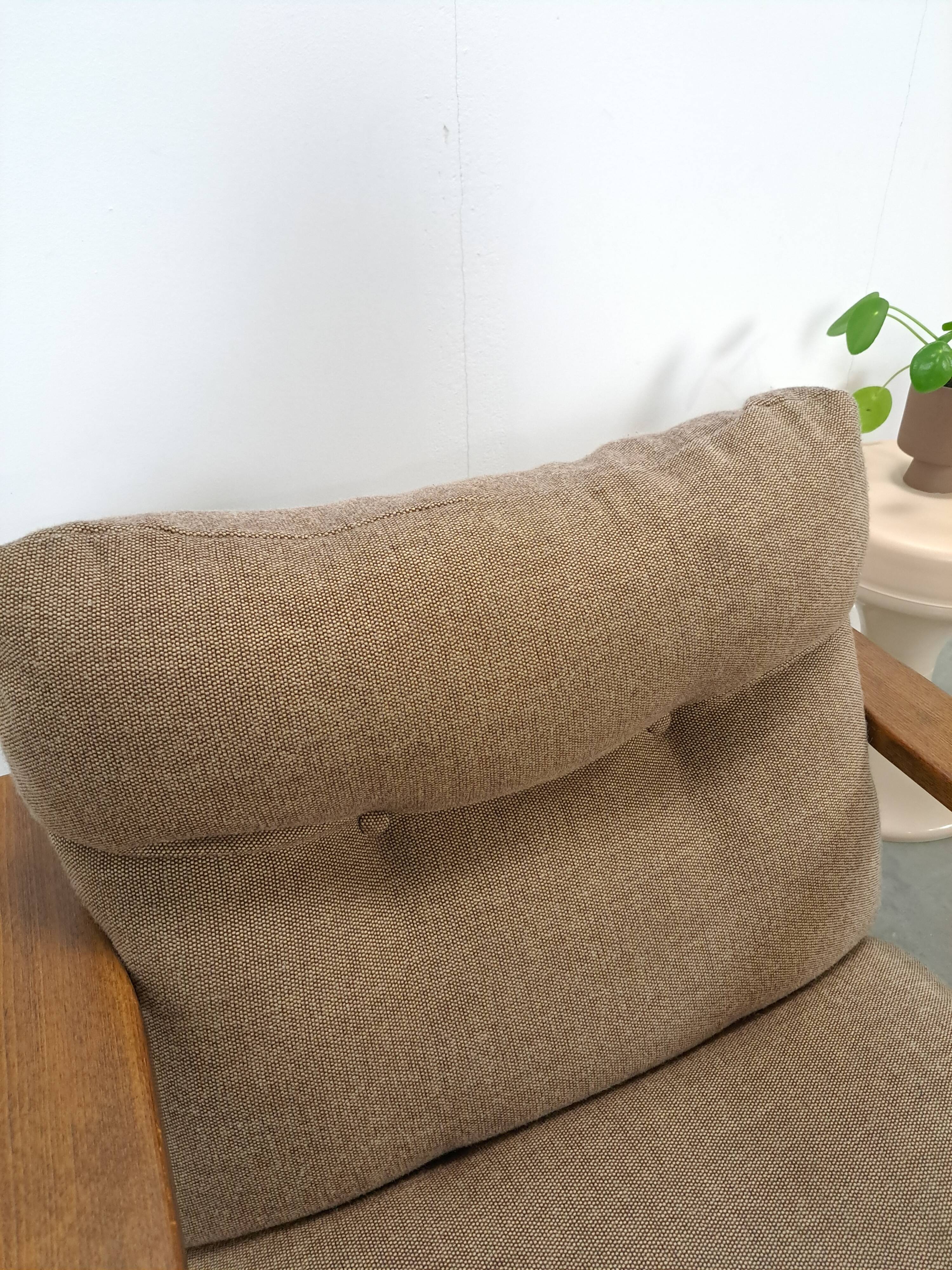 Brown-grey armchair with an oak frame.