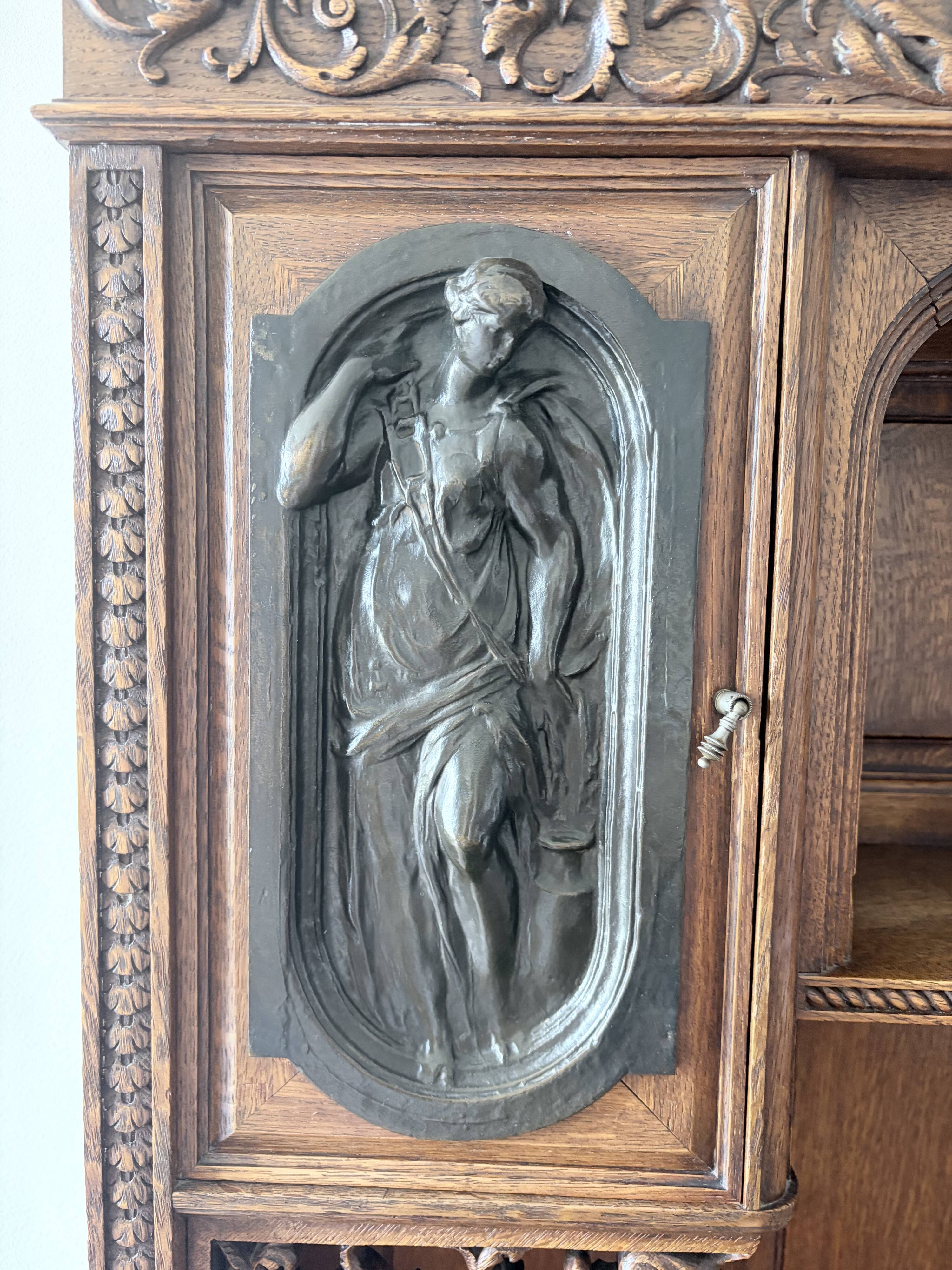 Large secretary with a drop-down front in carved oak, neo-Renaissance style.