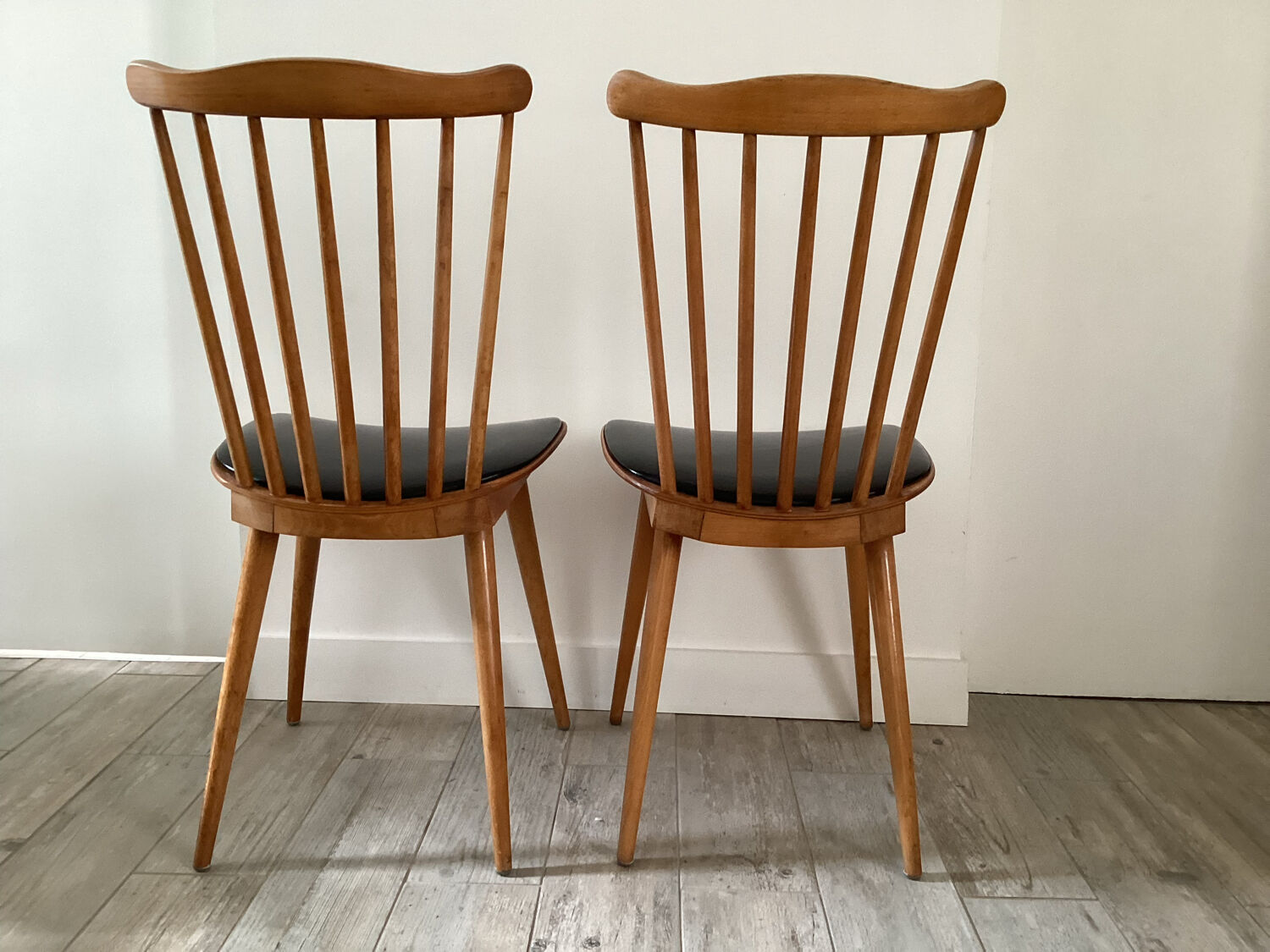 2 baumann chairs seated in imitation black leather