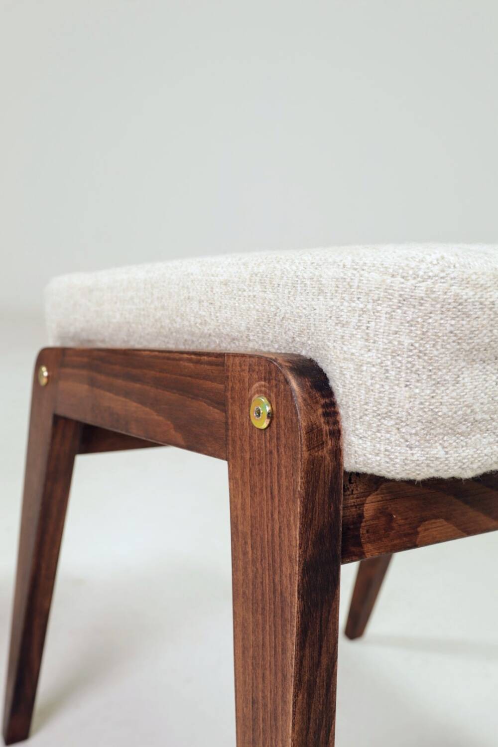 Pair of wooden stools with beige fabric.