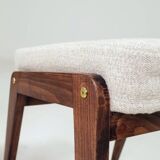 Pair of wooden stools with beige fabric.