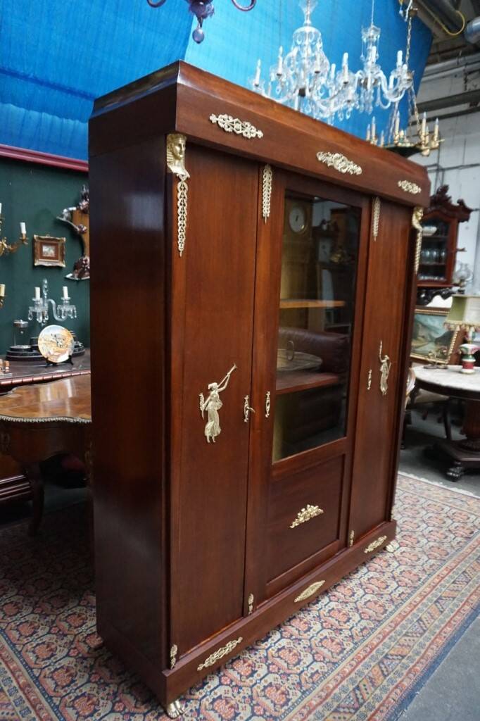 Empire style mahogany display bookcase with gilt bronze decoration and three doors.