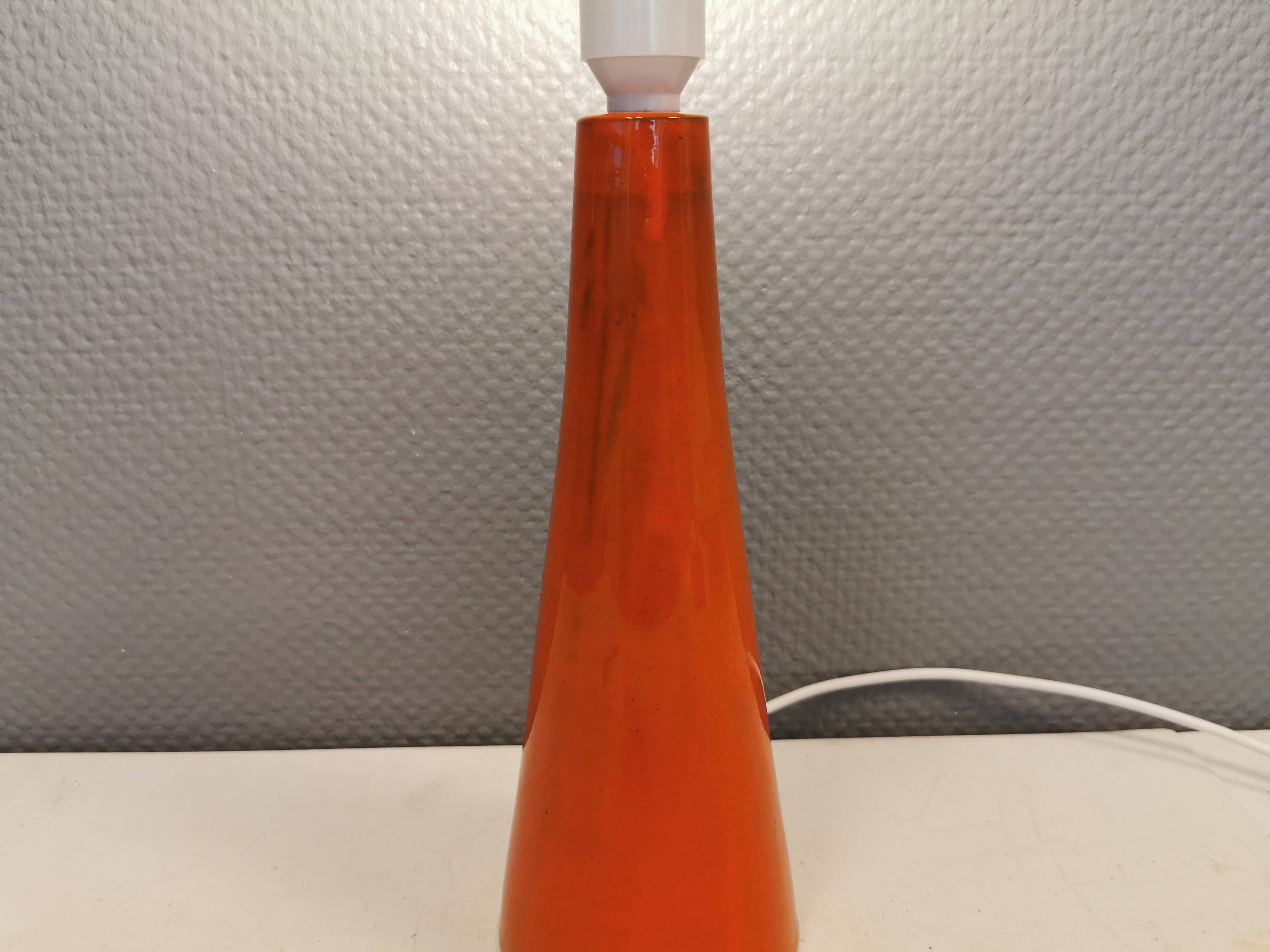 Ceramic table lamp with partial orange glaze.
