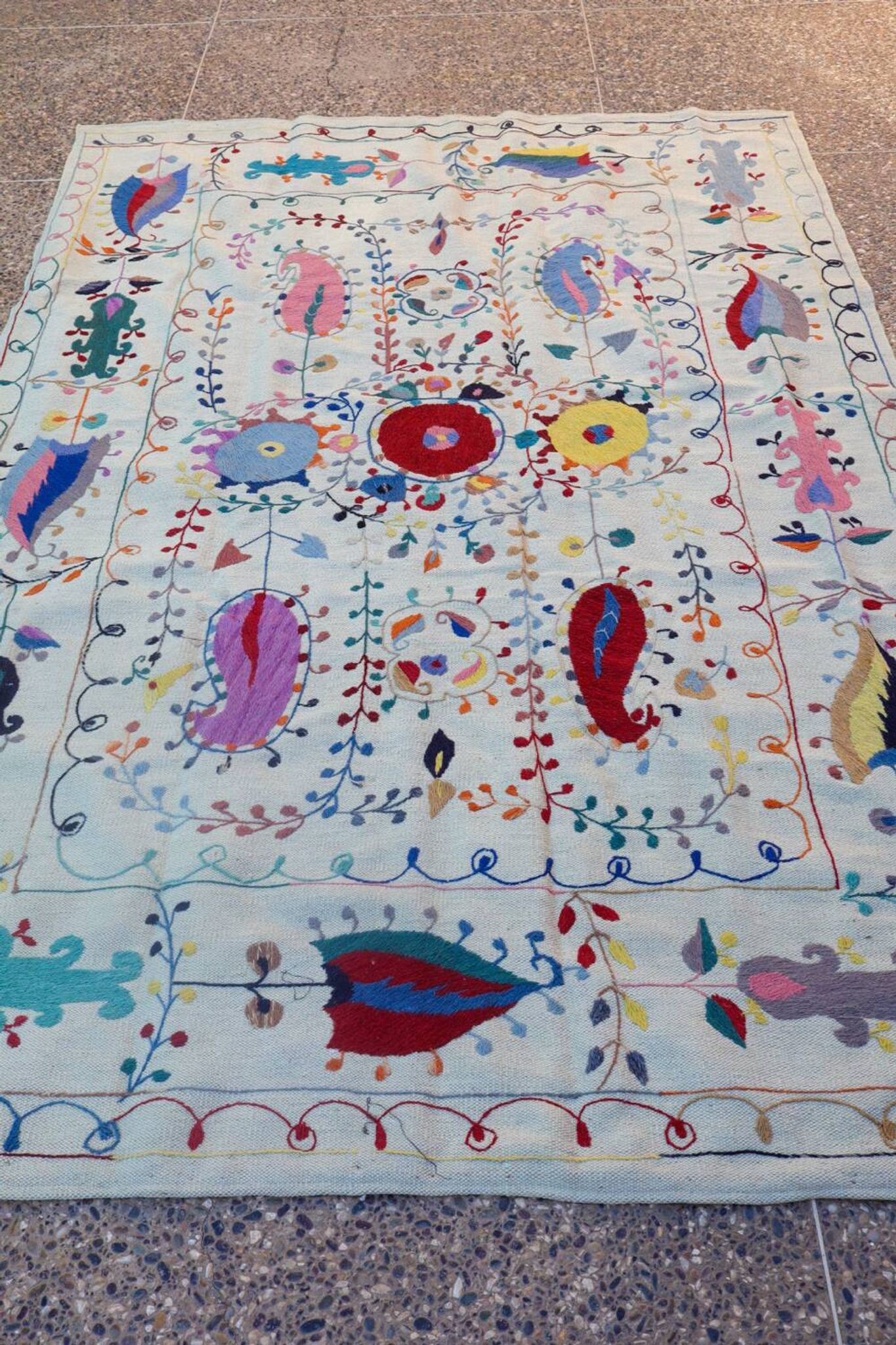White suzani kilim rug with hand embroidered multi-colored patterns