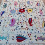 White suzani kilim rug with hand embroidered multi-colored patterns