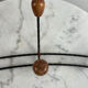 Wall-mounted coat rack in wrought iron with turned wooden knobs.