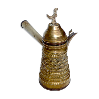 Antique ewer in bronze, brass and copper repelled by hand decorated with a bird in its juice!.