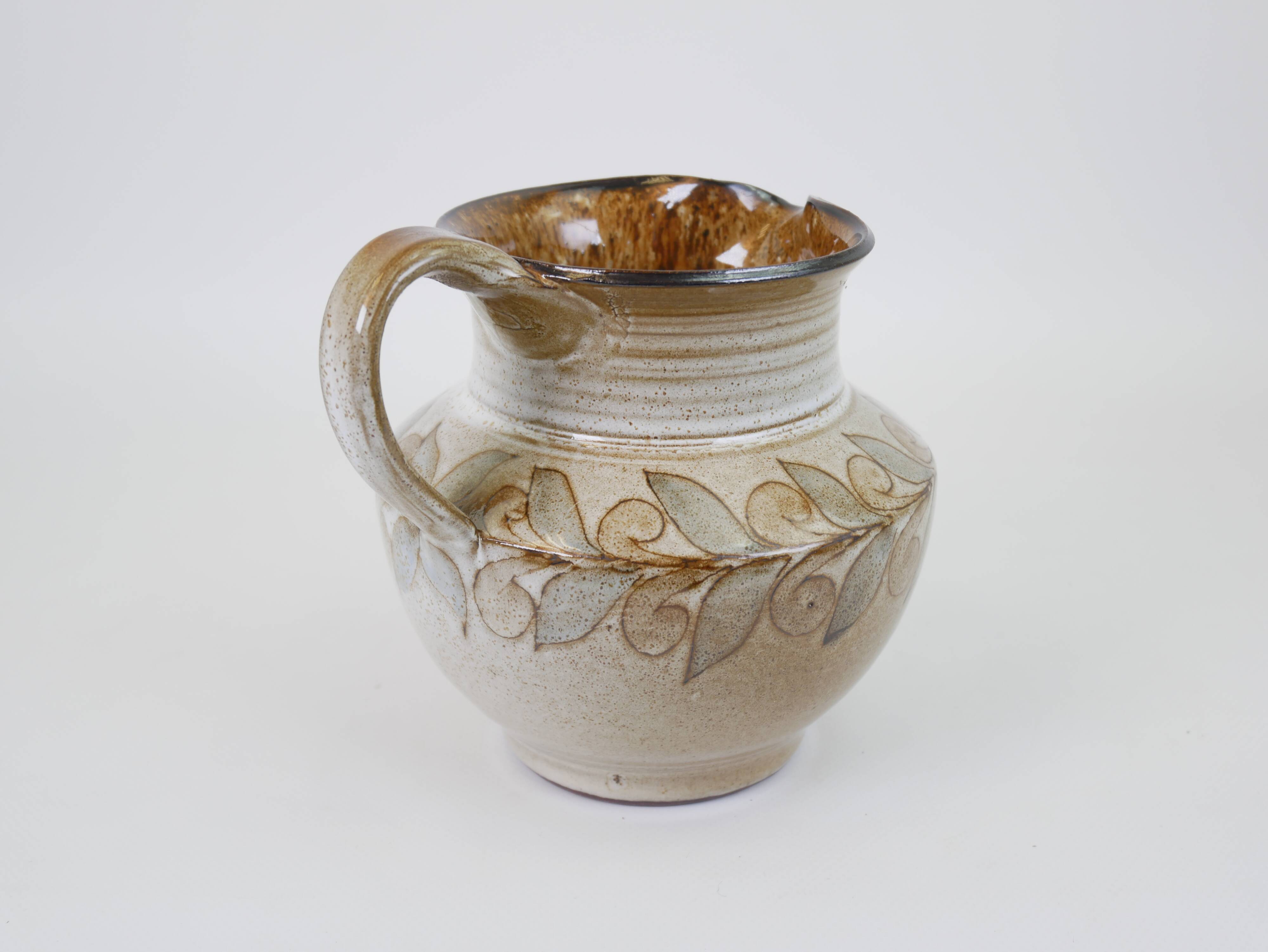 Glazed ceramic jug with plant decoration