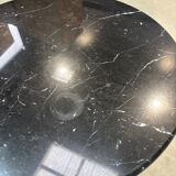 Round marble table with a black metal tulip base.