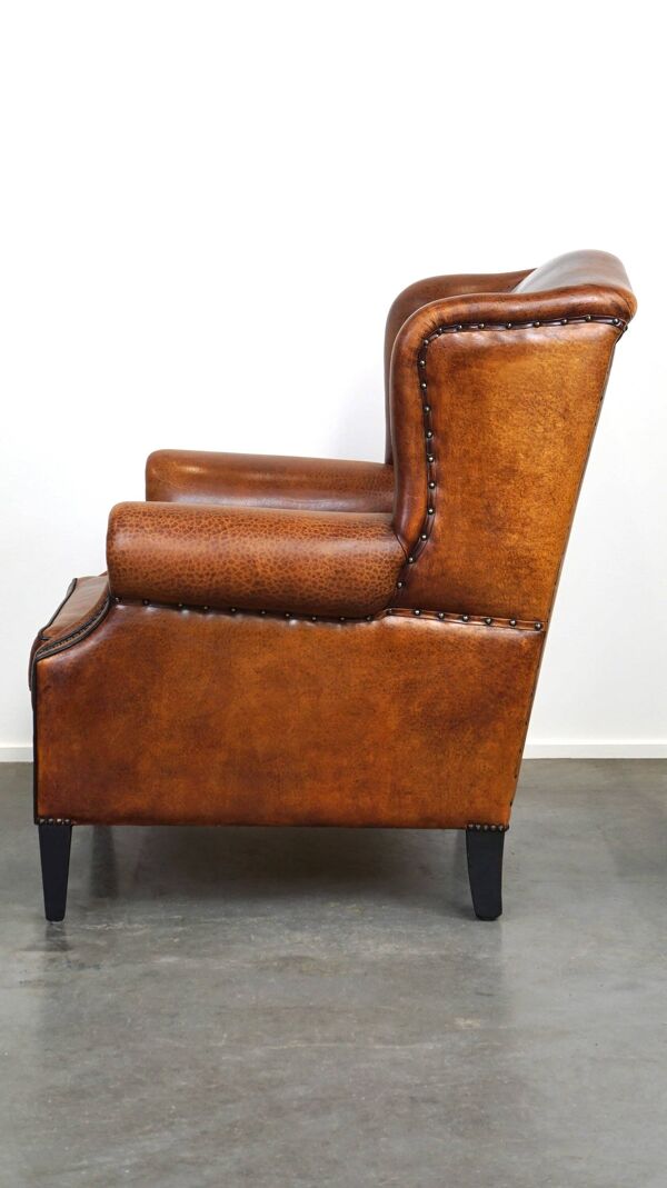 Fauteuil à oreilles en cuir de mouton, avec clous et passepoil noir