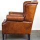 Sheepskin leather wingback armchair, with nails and black piping