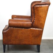 Sheepskin leather wingback armchair, with nails and black piping