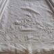 Antique embroidered linen sheet with a monogram.