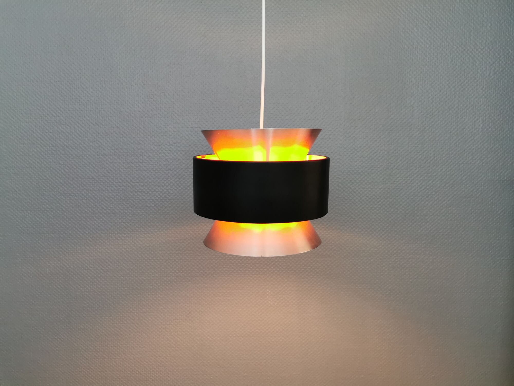 Hanging lamp,  of silver coloured aluminium with black "ring" and orange inner contrast lacquer.
