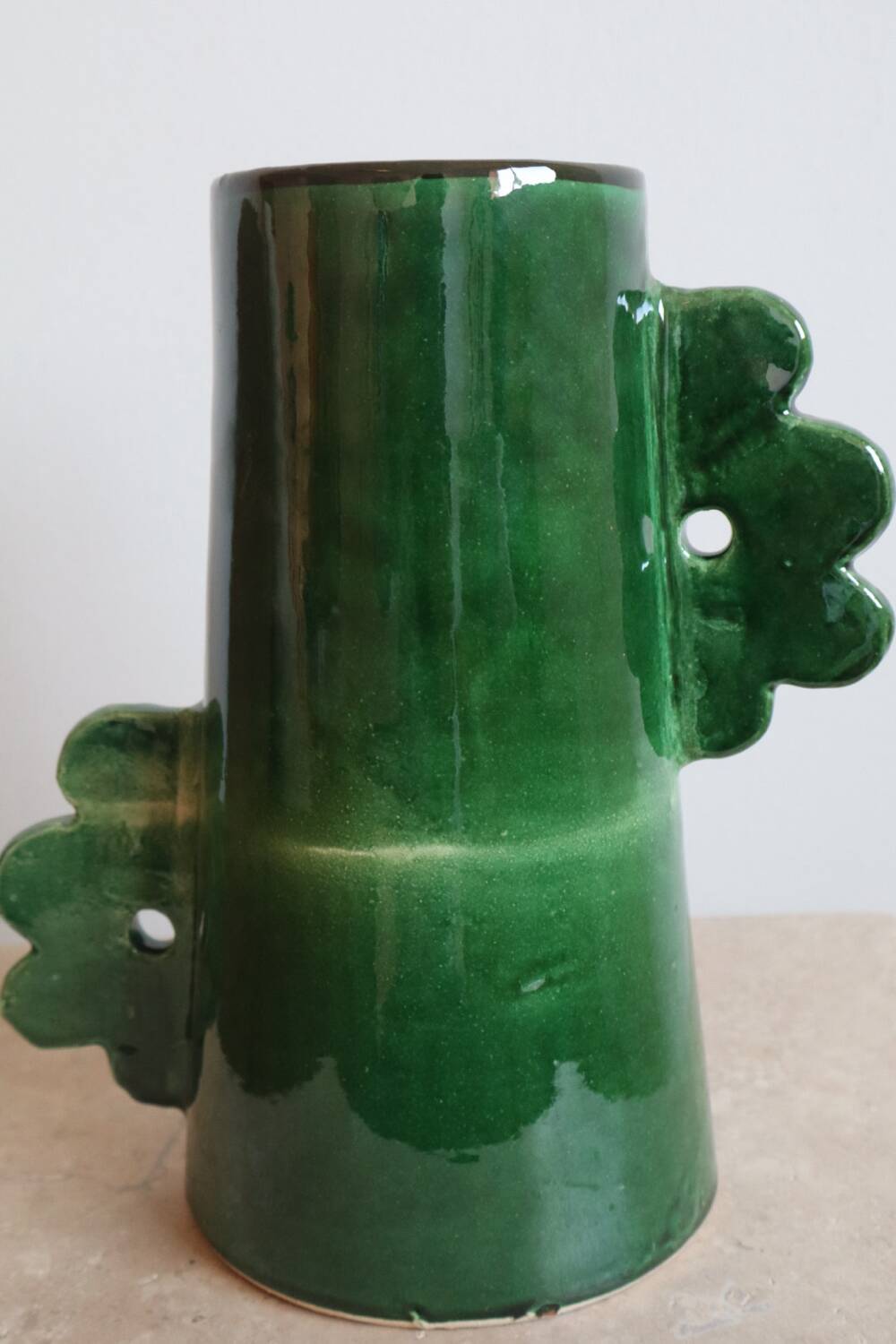 Handmade ceramic abstract vase with asymmetrical handles and fir green flowers