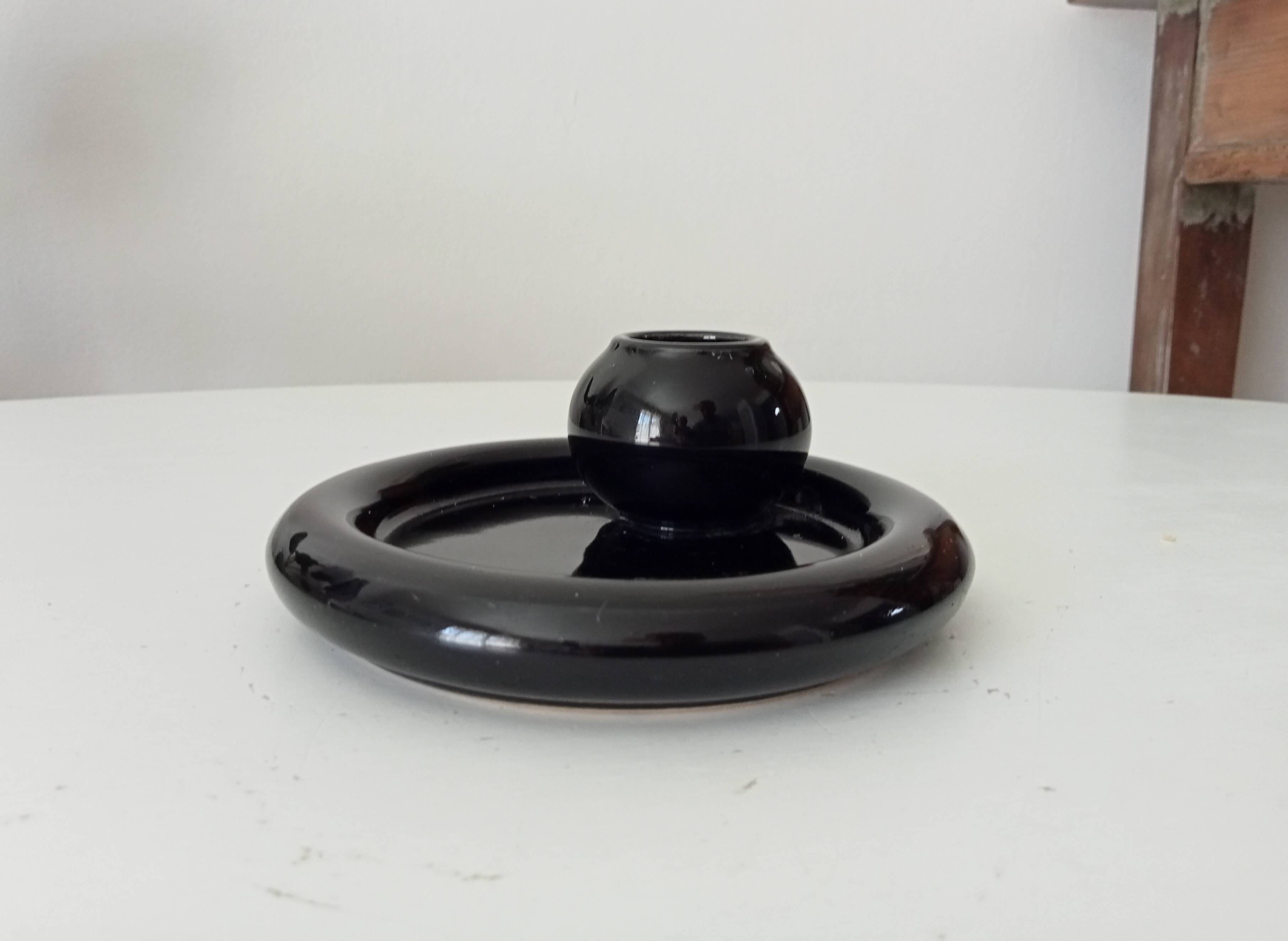 Vintage black ceramic candle holder on a bowl