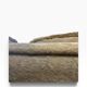 Vintage beige three-seater sofa with floral pattern and fringes.