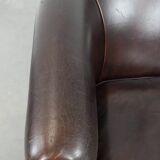 Dark brown vintage club armchair in English style made of sheepskin leather