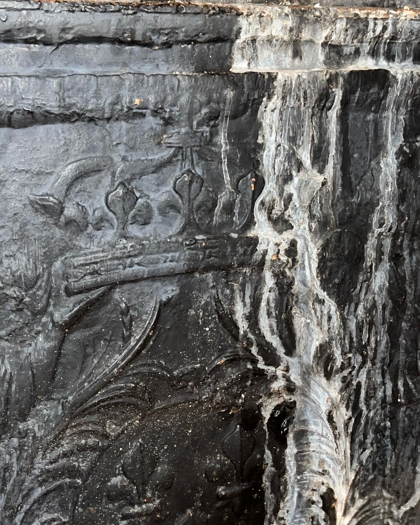 huge old fireplace plate has decoration of angels, crown and fleurs-de-lis