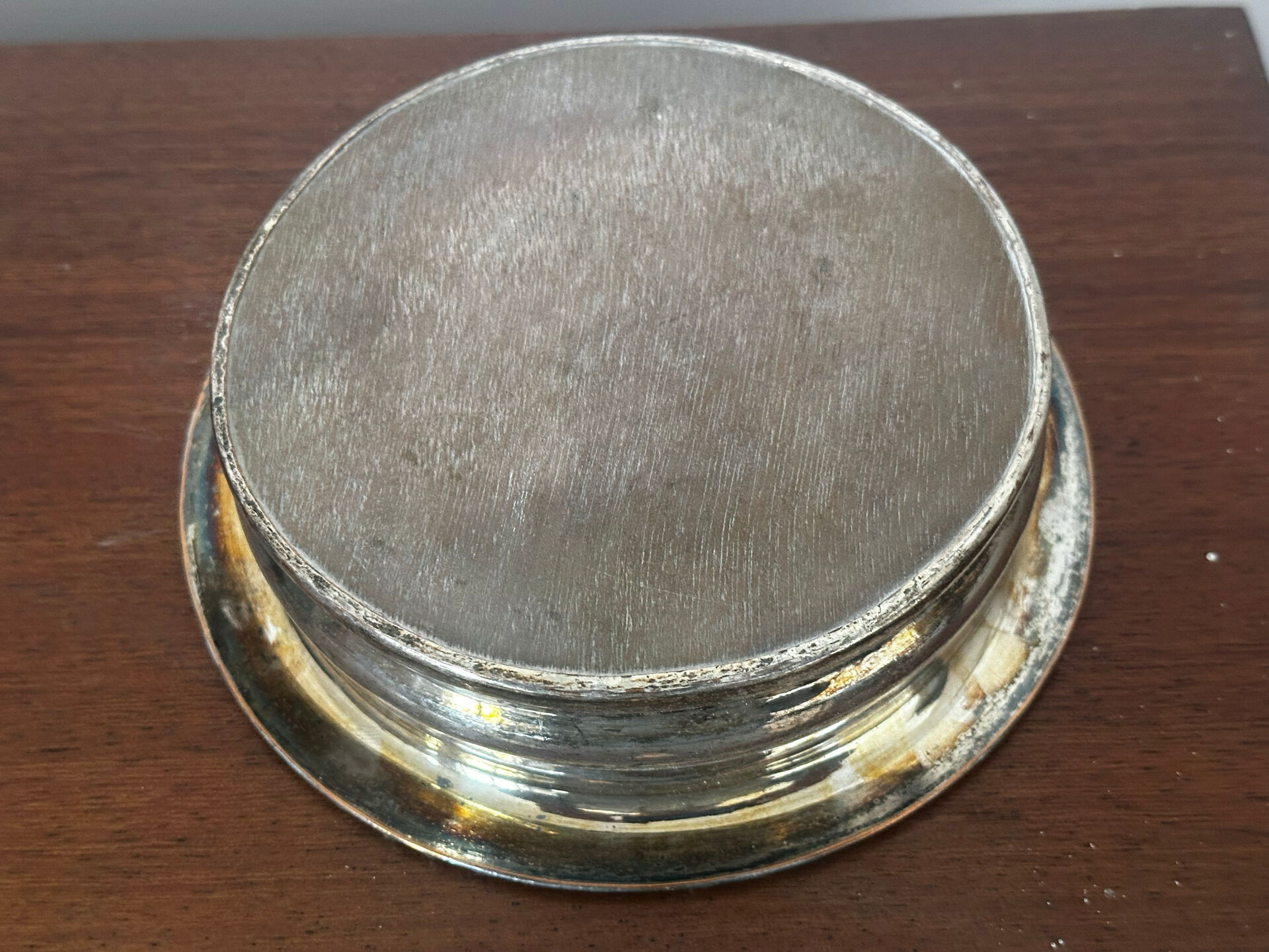 Antique silver-plated bottle coaster with floral decoration.