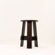 Vintage black-stained wooden tripod stool with mortise joints.