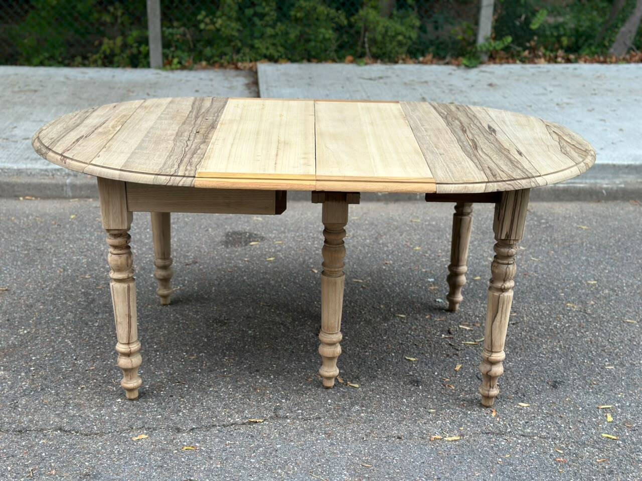 Round extendable dining table with flaps, stripped in raw oak, with 4 extensions.