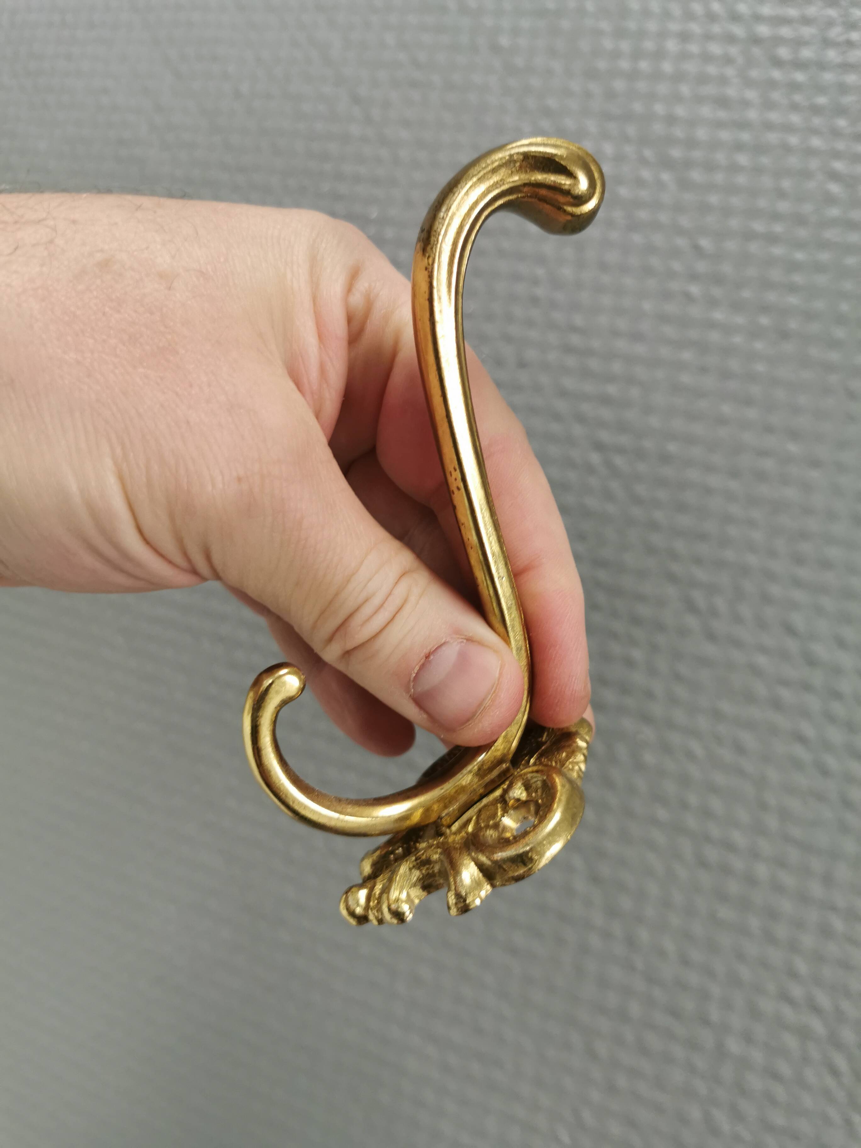 Three old and beautiful brass hooks with decorative motifs