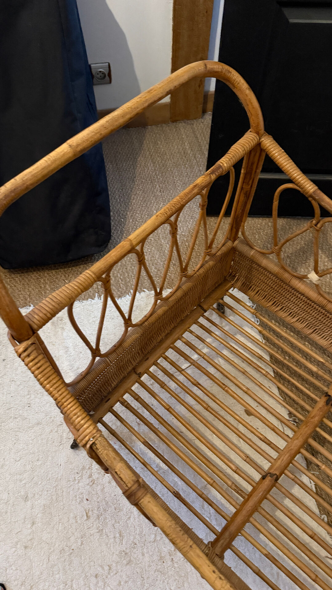 Vintage rattan baby cot on wheels.