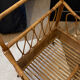 Vintage rattan baby cot on wheels.