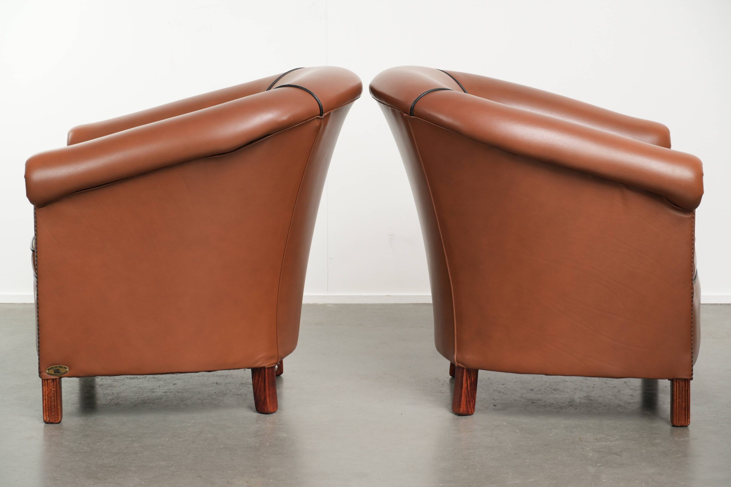 Ensemble de 2 fauteuils club en cuir de vache en bon état dans le style anglais.
