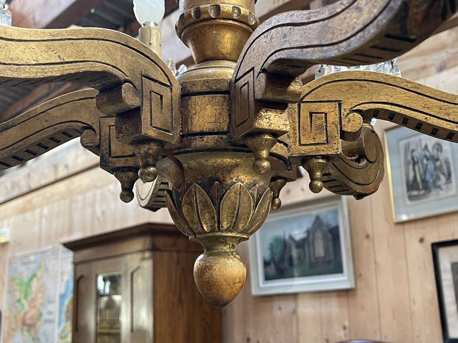 Golden wooden chandelier with crystal pendants from the 19th century.