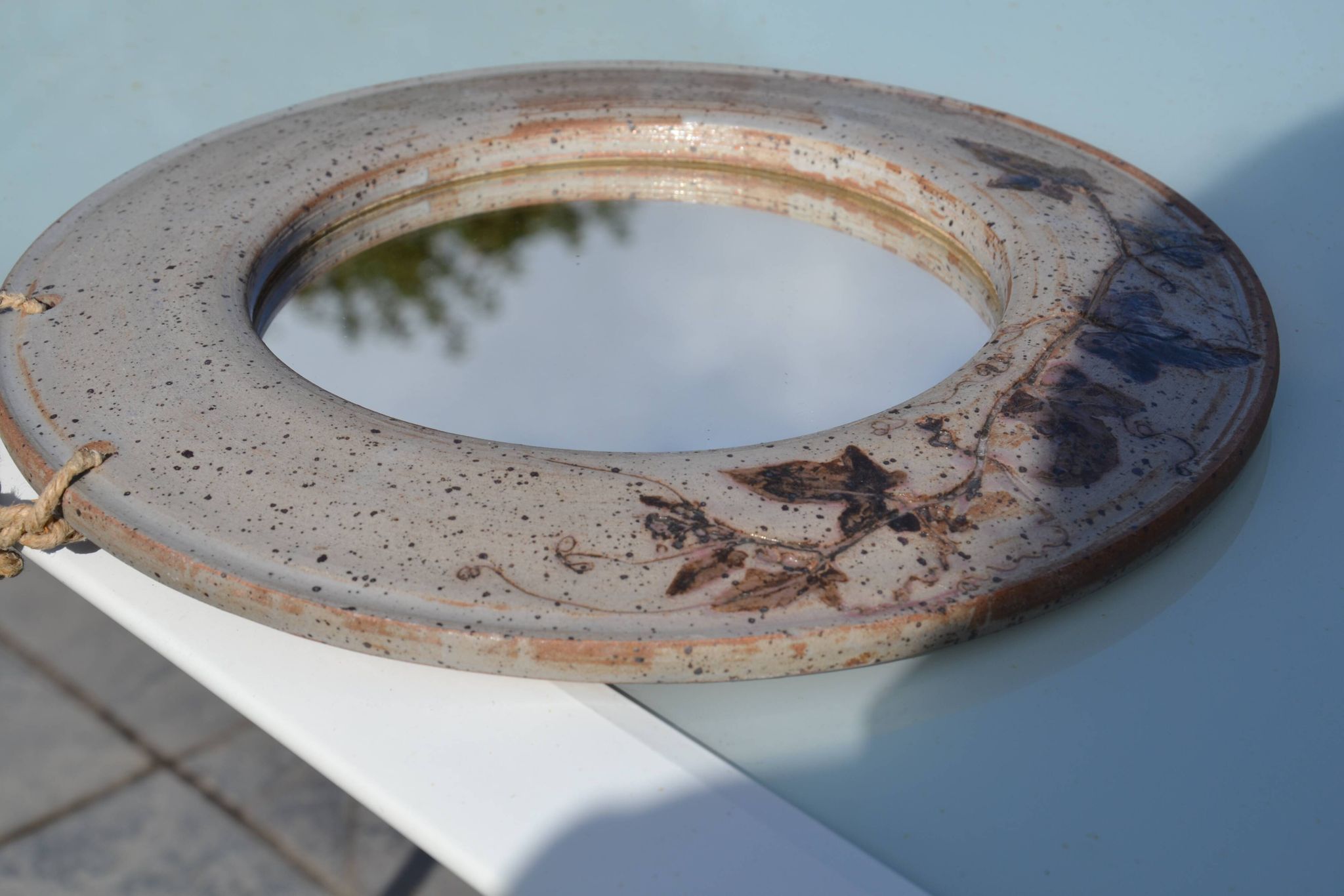 Miroir rond en céramique signé