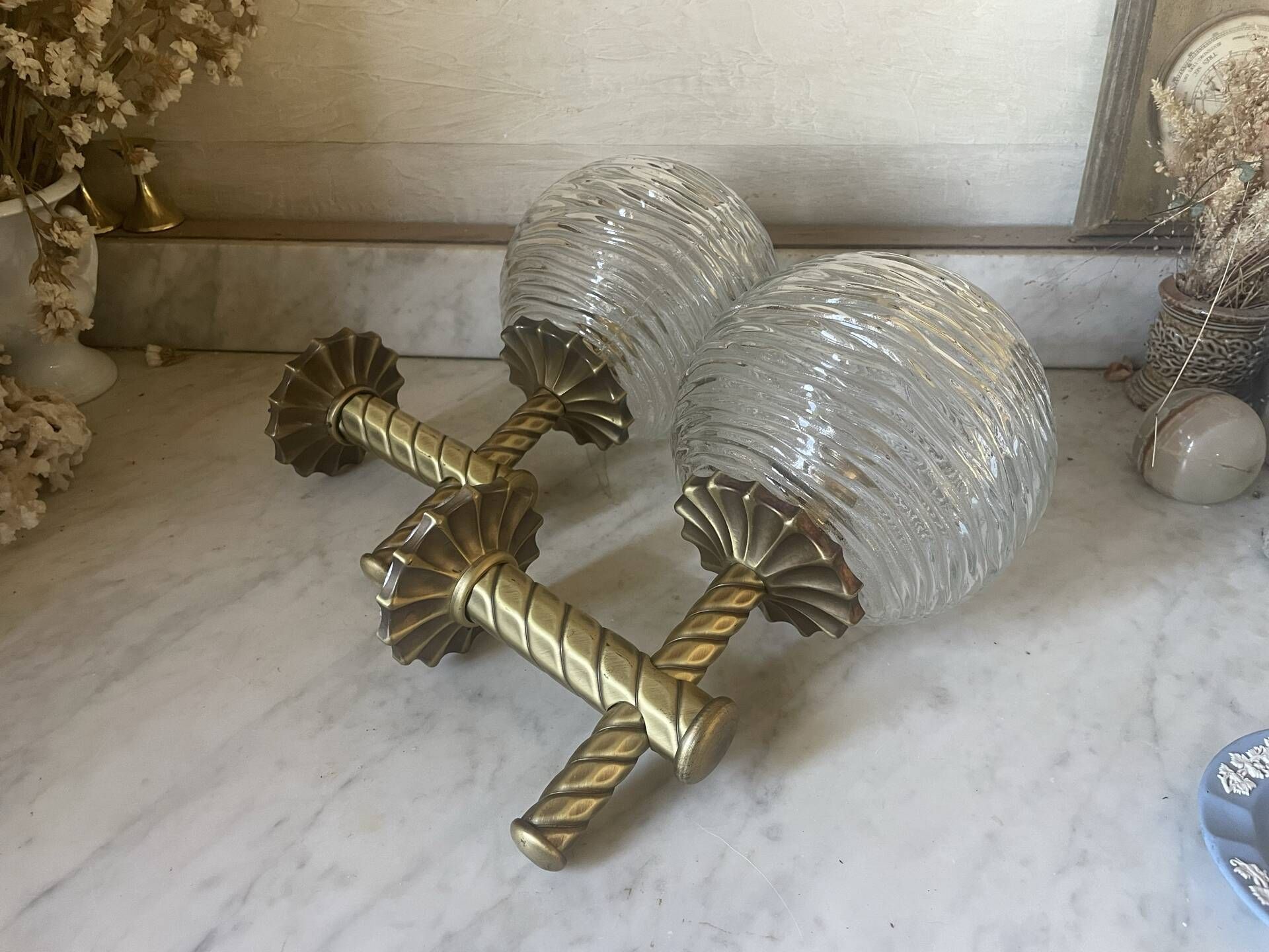 Pair of neoclassical wall sconces in twisted brass and ribbed glass.