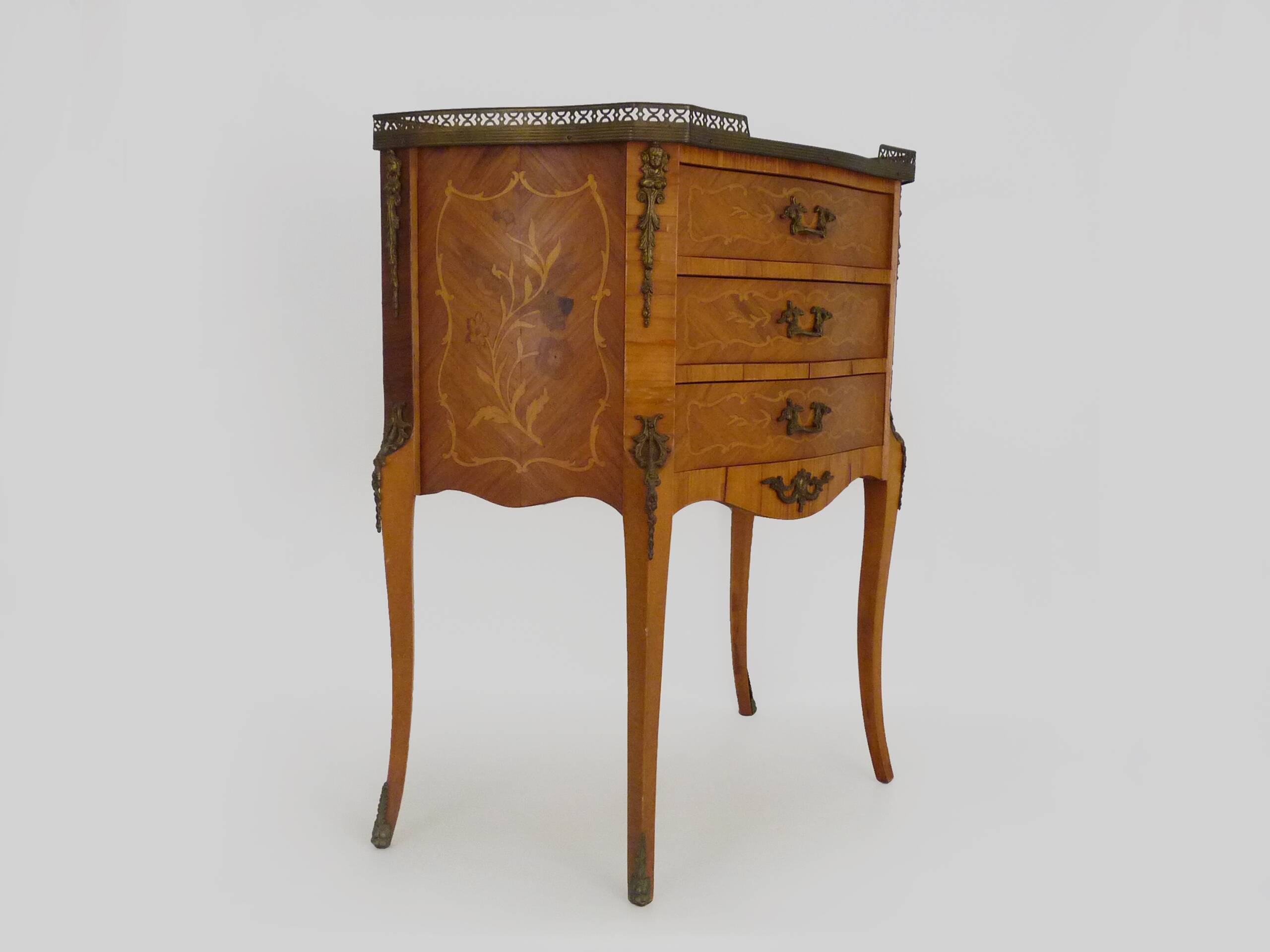 Baroque style wooden chest of drawers with bronze frieze.