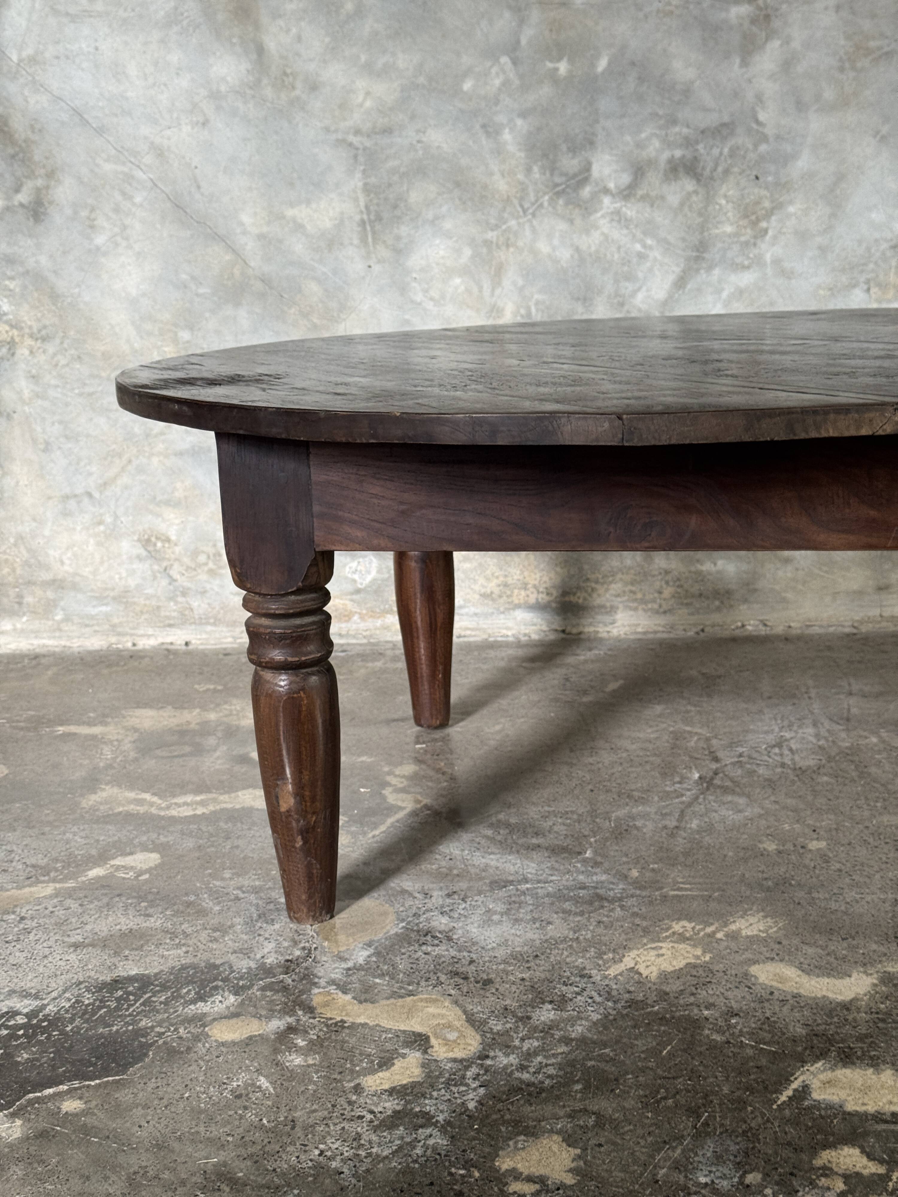 Coffee table, round antique Indonesian teak table with straight legs.