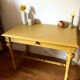 Desk table from the late 19th century, painted mustard, with turned stretcher.
