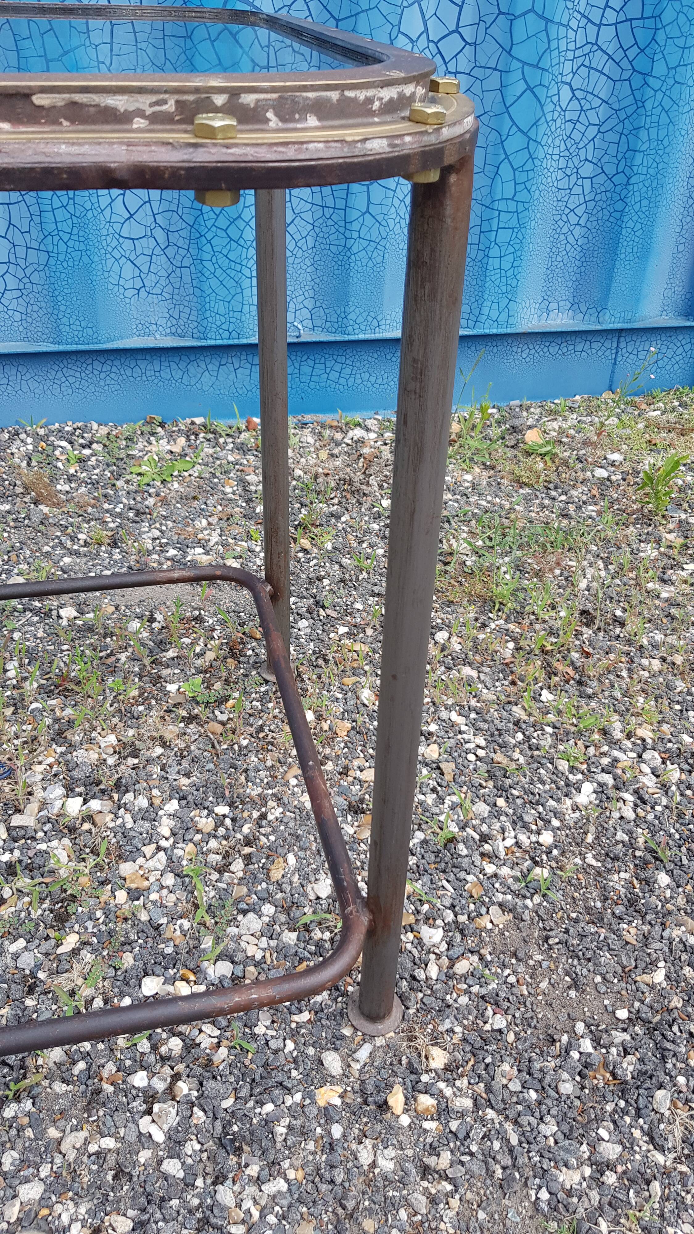 Table with an old ship porthole in brass and a metal base / 110 x 70 x 76 cm