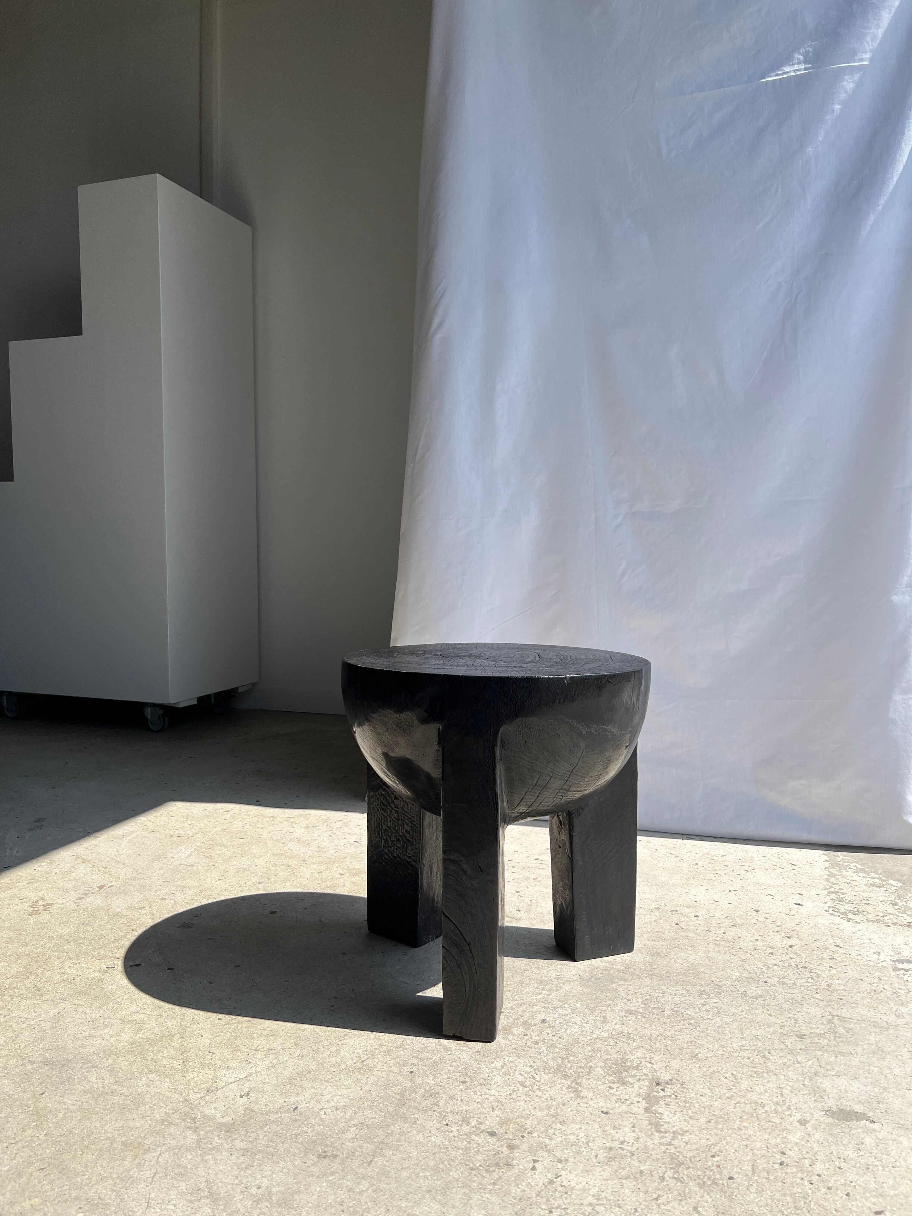 Black mango wood tripod side table with a semi-spherical top, height: 45 cm, diameter: 44 cm.
