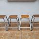 Set of four stackable industrial tubular metal and wood stools
