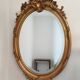 Antique oval mirror in gilded wood with gold leaf – bevelled glass –