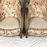 Paire de bergères en bois doré garnies de soie à motifs de fleurs, art déco d’inspiration Louis XVI
