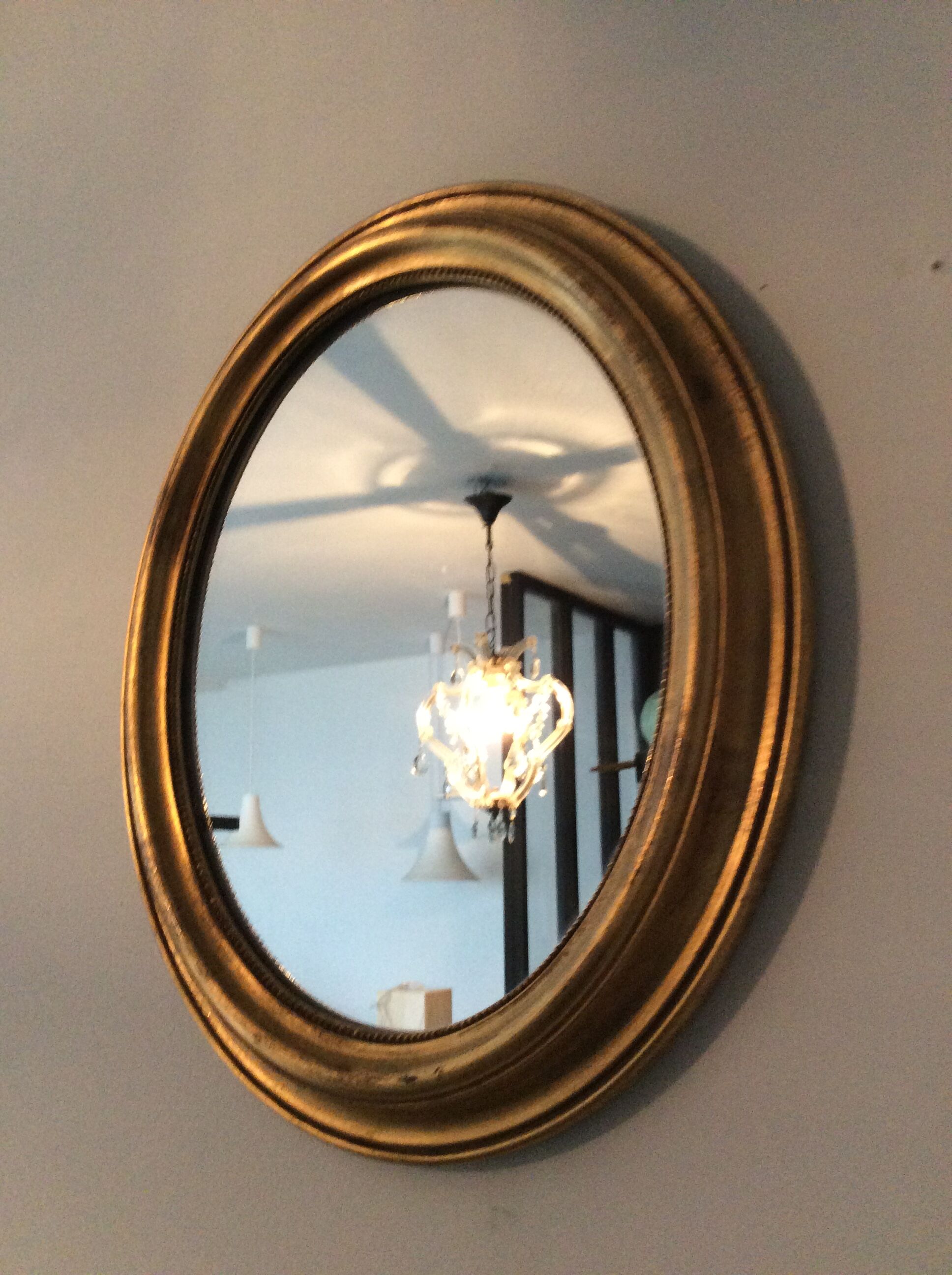 Old oval mirror in gilded wood