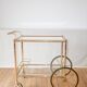 Serving table in gilded metal and glass with large wheels 1950
