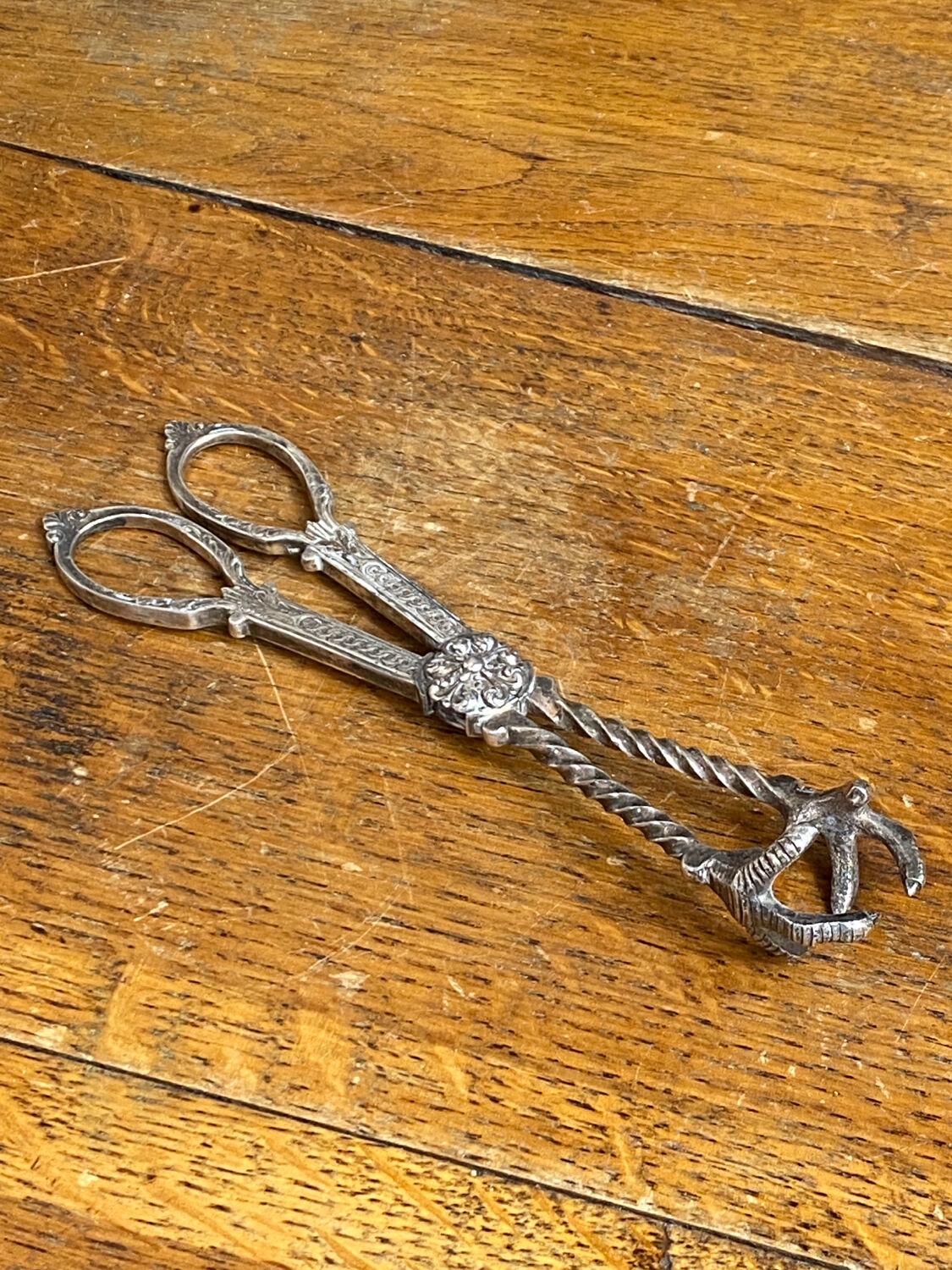 Sugar tongs or ice tongs in silver-plated metal.