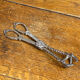Sugar tongs or ice tongs in silver-plated metal.