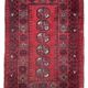 Bukhara Oriental carpet in wool with geometric patterns on a red background,