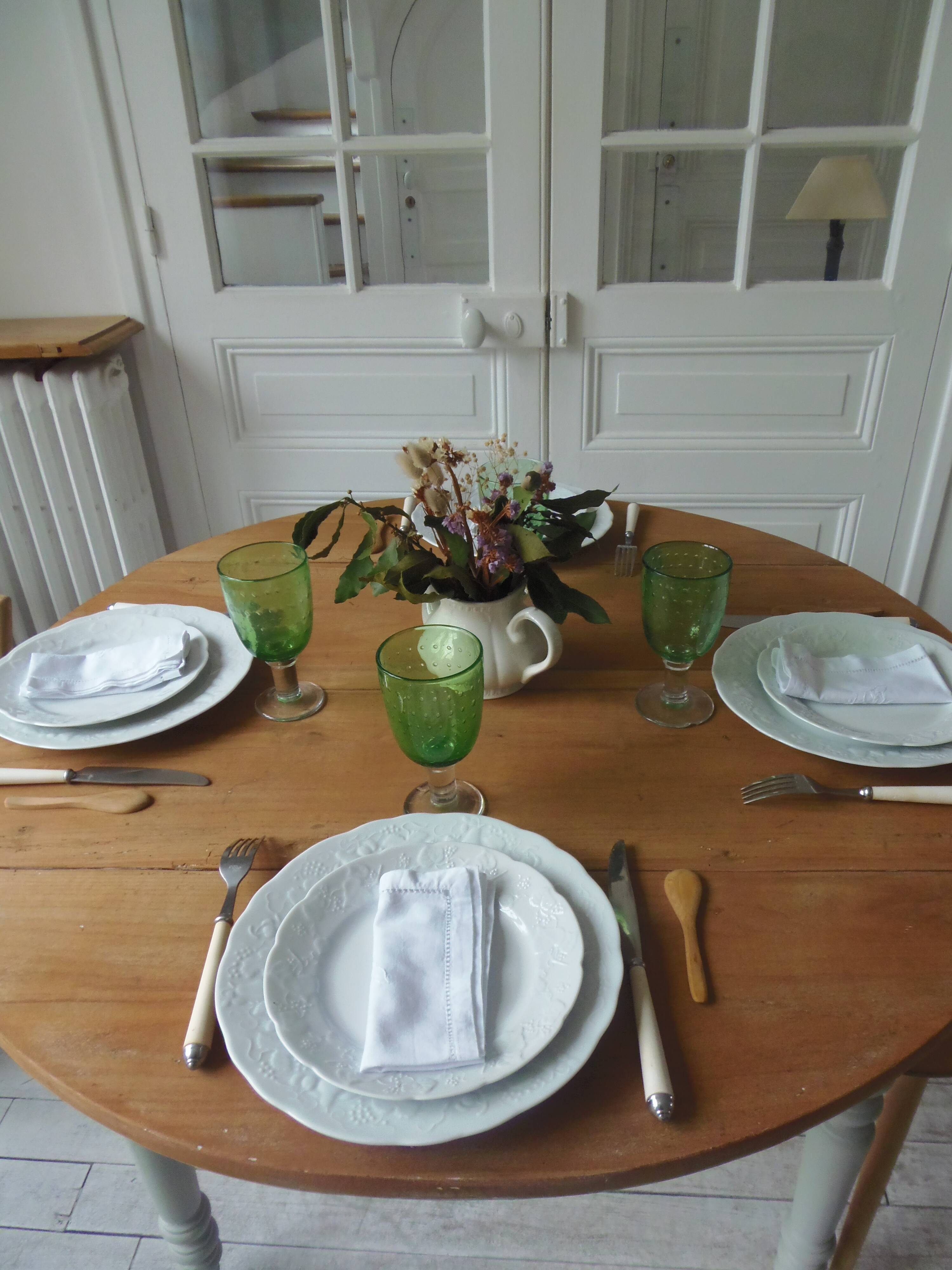 Raised walnut table with drop-leaf top, base on verdigris castors.